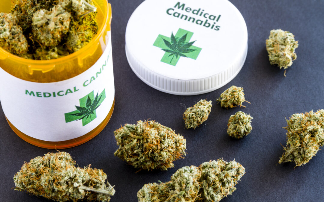 Medical marijuana buds in large prescription bottle with branded cap on black background